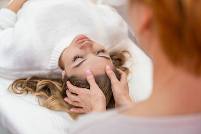 High angle view of young woman lying on bed at home