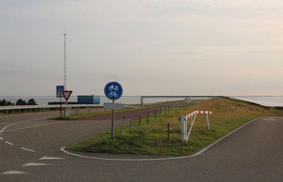 Road sign against sky