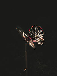 Low angle view of illuminated ferris wheel against black background