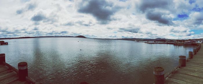 Pier on sea against cloudy sky
