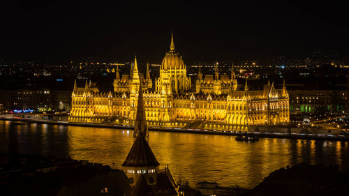 Illuminated city against sky at night