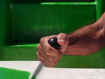 Cropped hand of man holding handle in motorboat