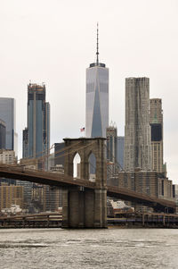 Modern buildings by river against clear sky