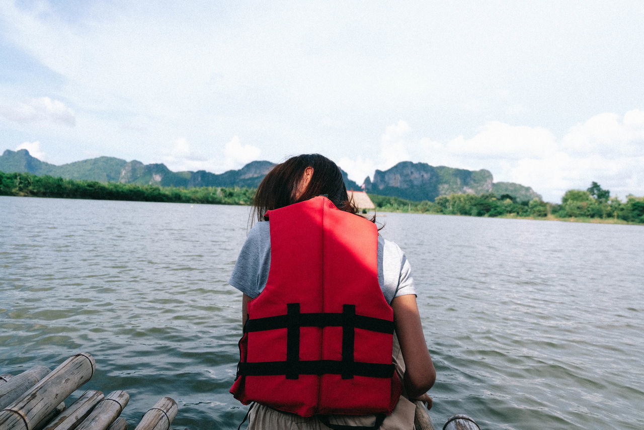 REAR VIEW OF WOMAN WITH RED UMBRELLA ON LAKE