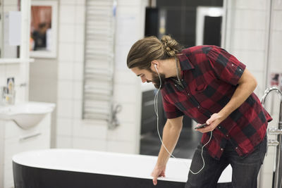 Male customer examining bathtub while shopping in hardware store