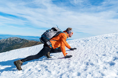 Man with snow on mountain against sky