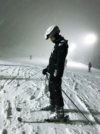 Person standing on snow covered mountain against sky