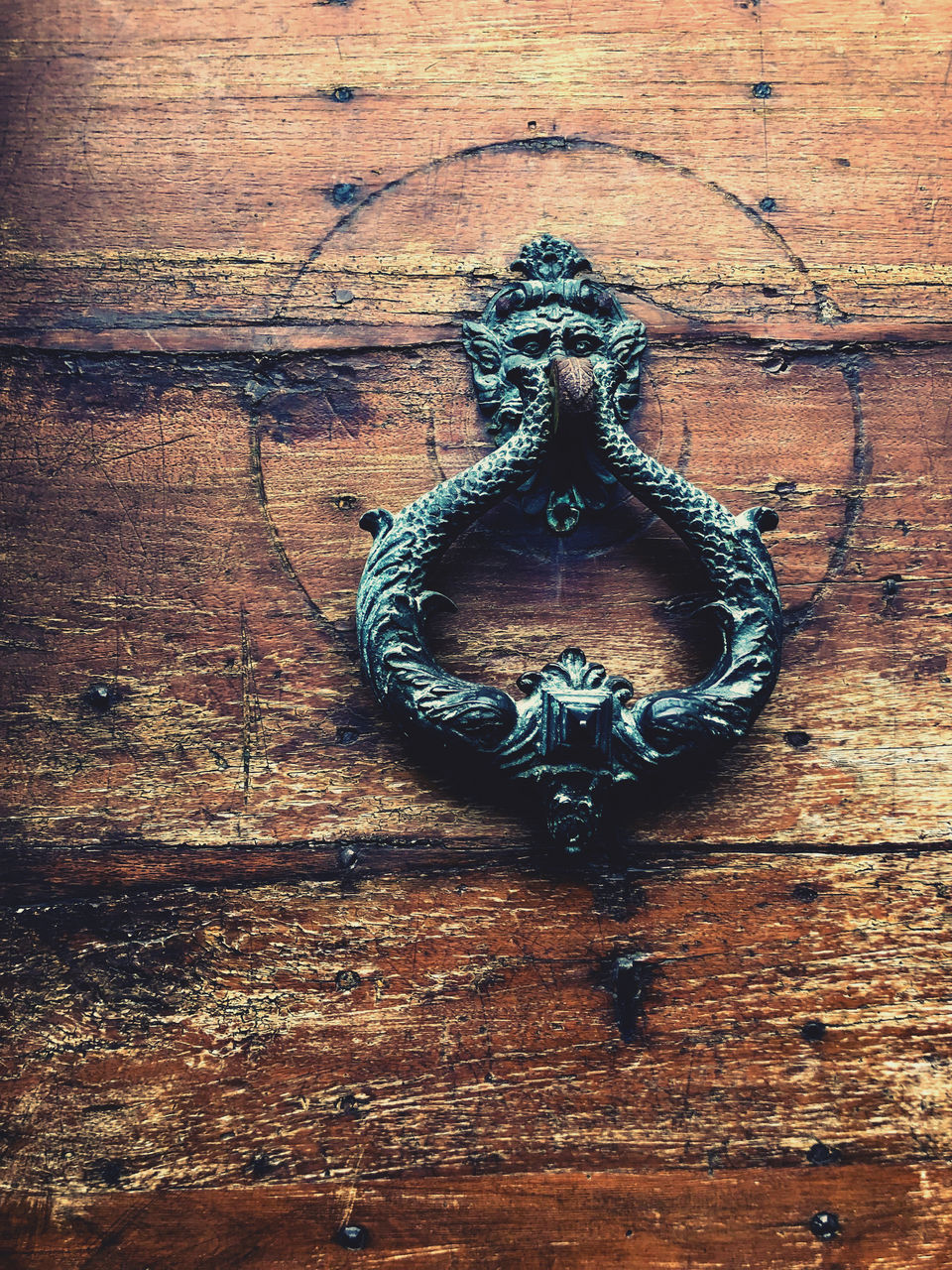 CLOSE-UP OF DOOR KNOCKER ON WOODEN WALL