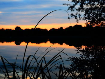 Scenic view of lake against sky at sunset