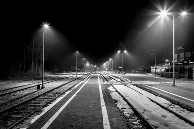 Illuminated railroad station platform at night during winter