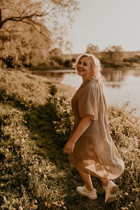 Portrait of young woman standing on field