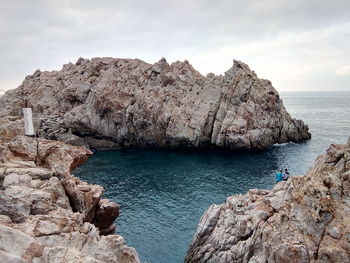 Rock formations by sea against sky