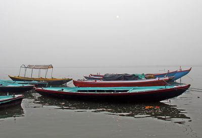 Boats moored on sea against sky