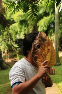 Close-up of man holding autumn tree