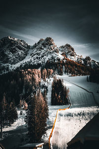 Italian alps and ski slopes in the dolomites with moody sky and snow.