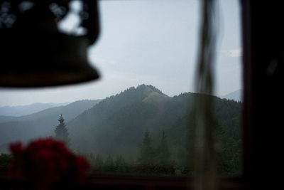 Scenic view of mountains against sky seen through window