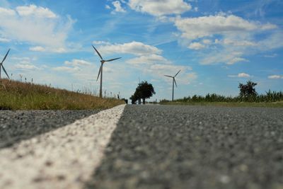 Wind turbines on landscape against sky