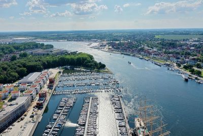 High angle view of city by sea against sky