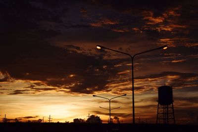 Lamp posts on landscape against scenic sky