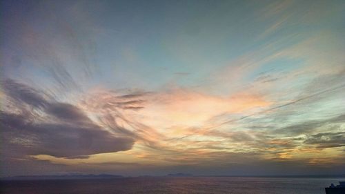 Scenic view of sea against dramatic sky during sunset