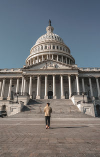 Full length rear view of senior woman against clear sky