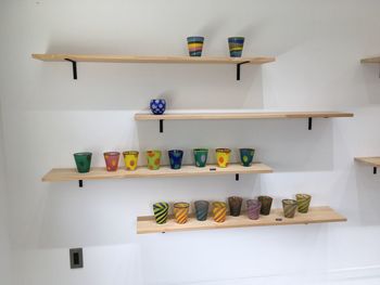 Various toys on shelf against wall at home