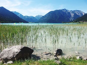 Scenic view of lake by mountains against sky