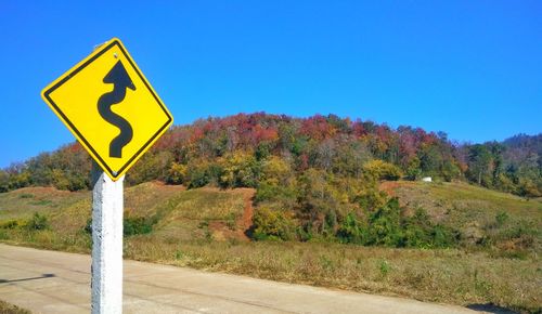 Road sign against clear blue sky