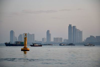 Ship in sea against sky in city