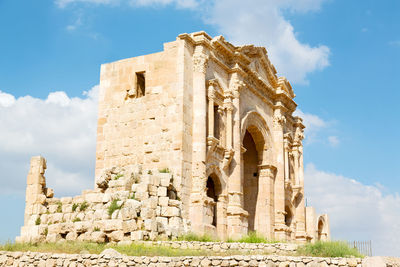 Low angle view of old ruin building against cloudy sky