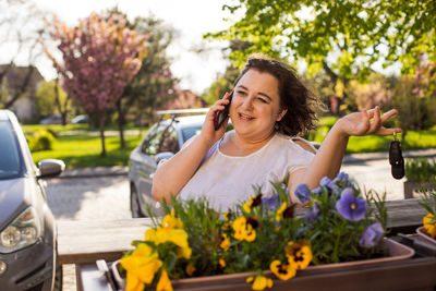 Portrait of smiling young woman holding flowers