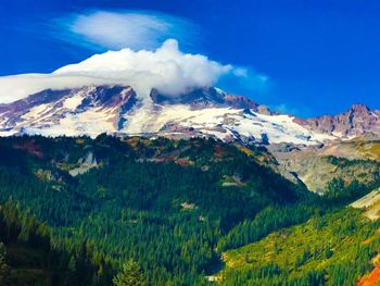 Scenic view of mountains against blue sky