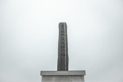 Low angle view of wooden post against clear sky