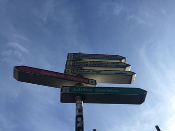 Low angle view of road signs against blue sky