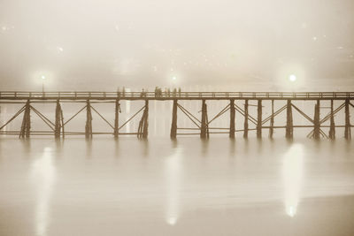 Old mon wood bridge bridge crossing a river at sangklaburi. people walking on the bridge.