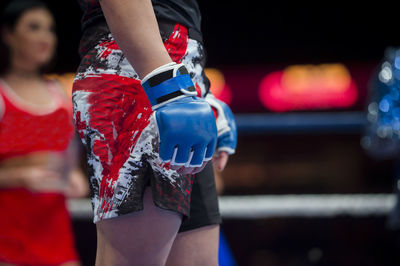 Midsection of shirtless boxer standing in boxing ring