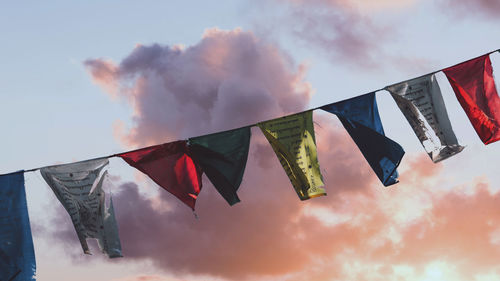 Low angle view of flags hanging against sky