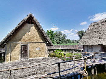 Old house by building against sky