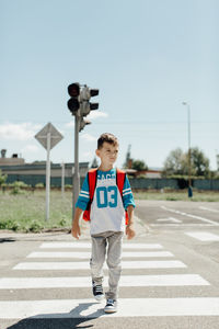 Boy crossing road in city