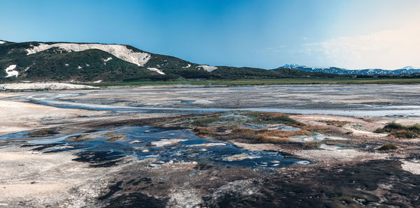 Scenic view of geysers against clear blue sky