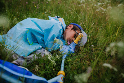 High angle view of boy lying down on grassy land