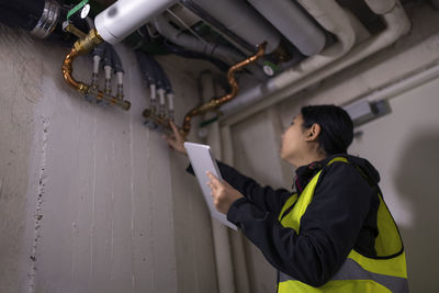 Female plumber checking pipes