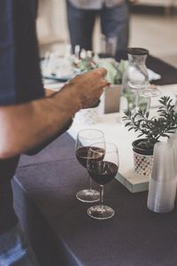 Close-up of hand holding drink on table