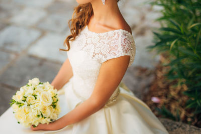 Midsection of woman holding flower bouquet