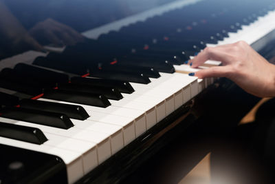 Cropped hand of woman playing piano