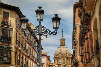 Low angle view of street lights by cathedral-basilica of our lady of the pillar against sky