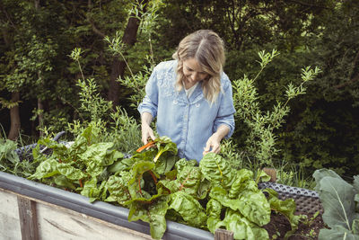 Woman wearing mask against plants