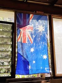 Low angle view of flag against window