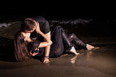 Young woman with hands in water at night