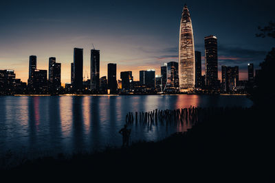 Illuminated buildings in city against sky